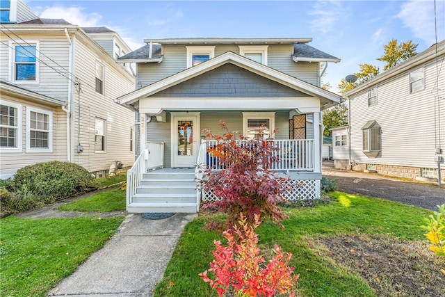 view of front of house with covered porch and a front yard