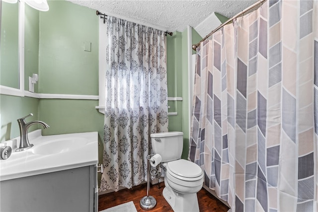 bathroom featuring a textured ceiling, toilet, walk in shower, vanity, and hardwood / wood-style flooring