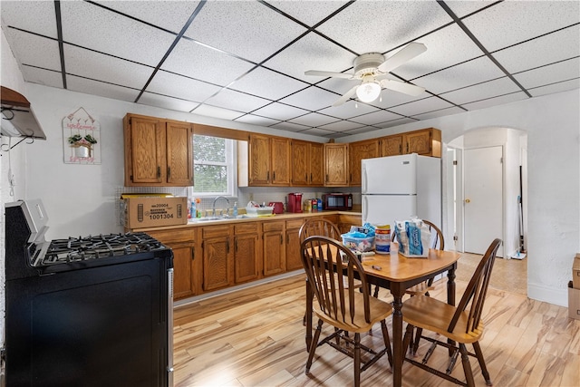 kitchen featuring sink, black appliances, light wood-type flooring, and ceiling fan