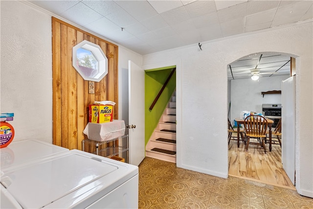 clothes washing area with ceiling fan, wood-type flooring, ornamental molding, and washer and dryer