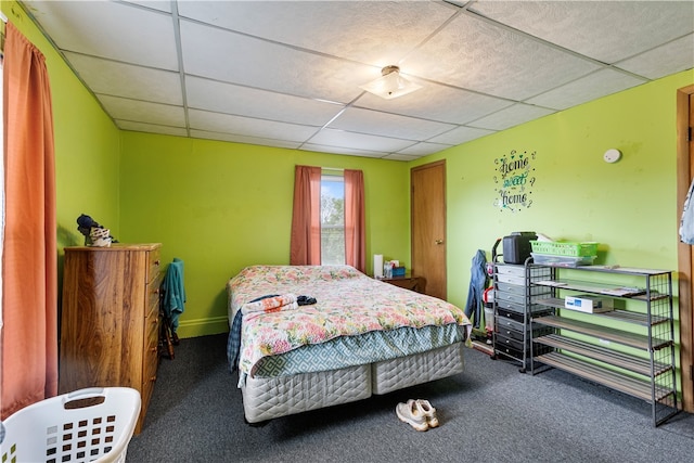 carpeted bedroom featuring a drop ceiling