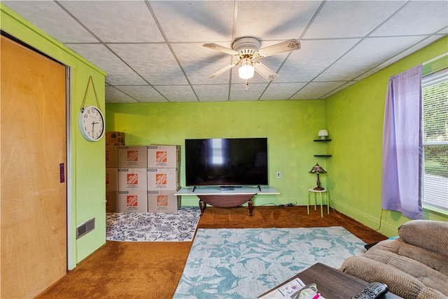 living room with a paneled ceiling, carpet flooring, and ceiling fan