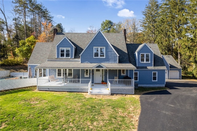 view of front of property featuring a porch, a front lawn, and a garage