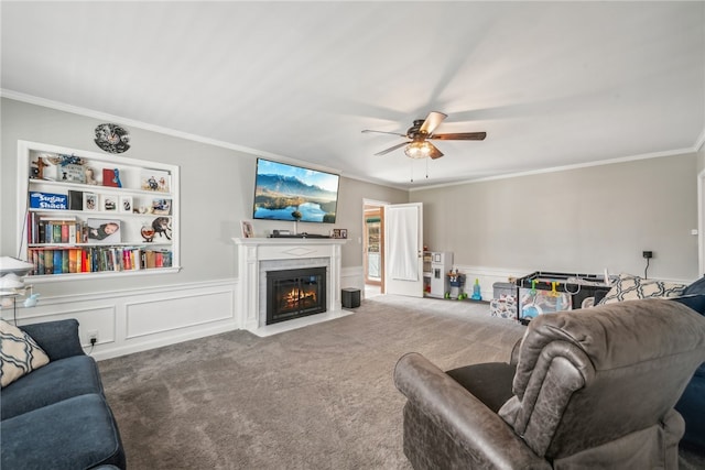 carpeted living room with crown molding and ceiling fan