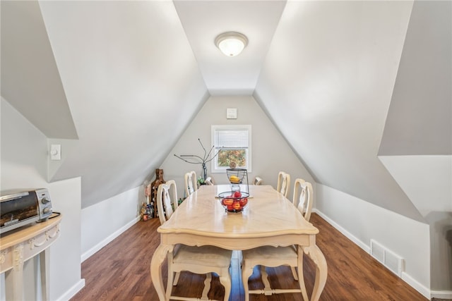 dining space with vaulted ceiling and dark hardwood / wood-style flooring