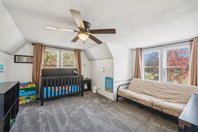 carpeted bedroom with a textured ceiling, vaulted ceiling, and ceiling fan