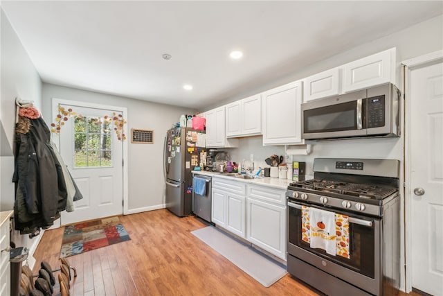 kitchen featuring appliances with stainless steel finishes, white cabinetry, and light wood-type flooring