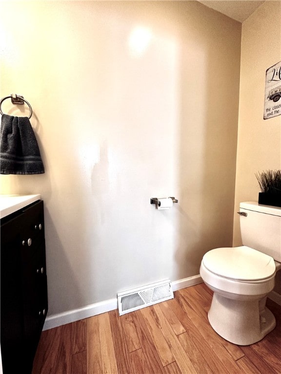 bathroom with vanity, hardwood / wood-style floors, and toilet