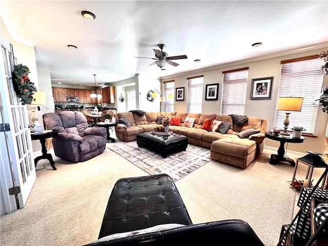 carpeted living room with crown molding and ceiling fan