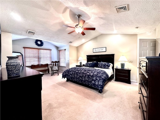 carpeted bedroom with vaulted ceiling, a textured ceiling, and ceiling fan