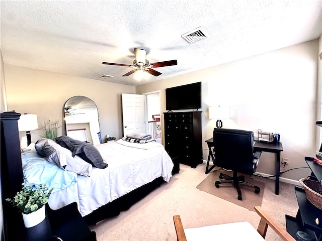 bedroom with ceiling fan, carpet flooring, and a textured ceiling