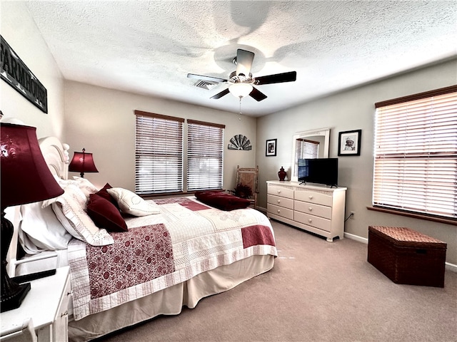 carpeted bedroom with a textured ceiling and ceiling fan