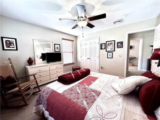 carpeted bedroom featuring a textured ceiling, a closet, and ceiling fan