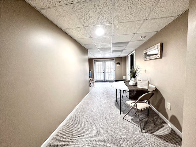 hall featuring french doors, a paneled ceiling, and carpet flooring