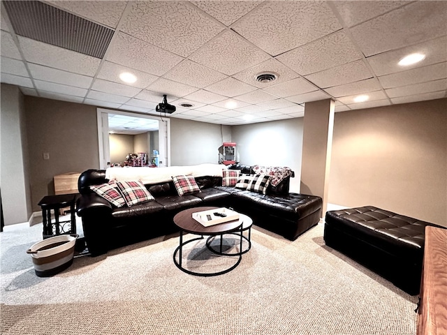 living room with a drop ceiling and light colored carpet