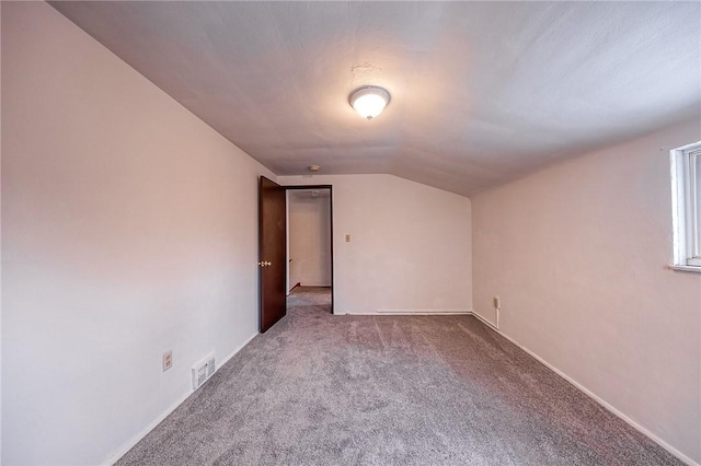 additional living space with vaulted ceiling and carpet flooring