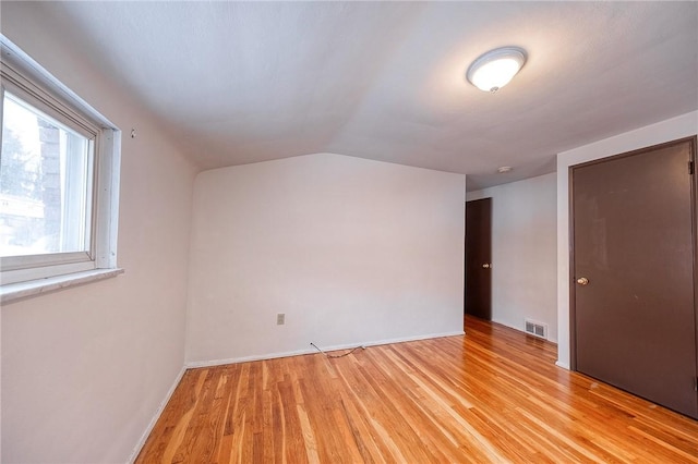 bonus room with vaulted ceiling and light wood-type flooring