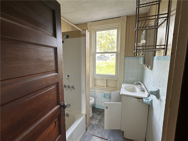 full bathroom with vanity, toilet, bathtub / shower combination, and tile walls