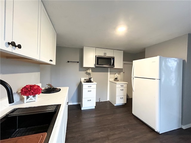 kitchen featuring white cabinets, dark hardwood / wood-style flooring, white fridge, and sink