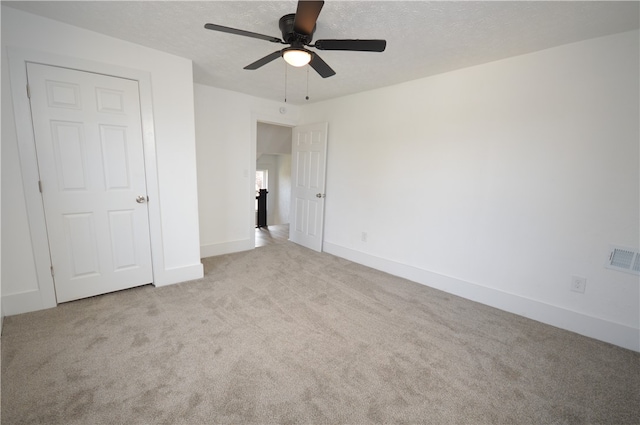 unfurnished bedroom with light colored carpet and ceiling fan