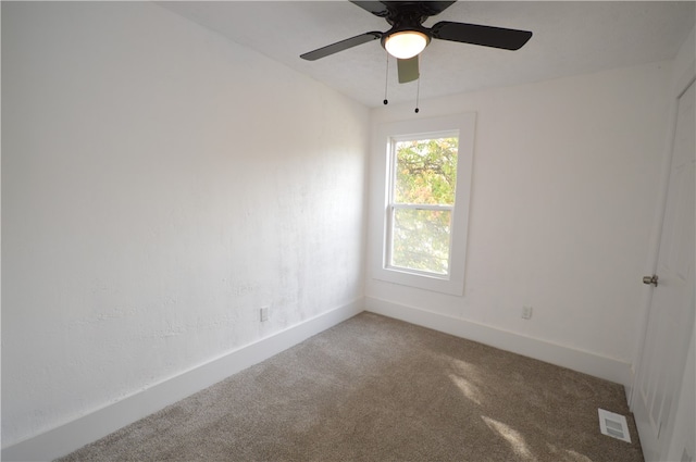 carpeted spare room featuring ceiling fan