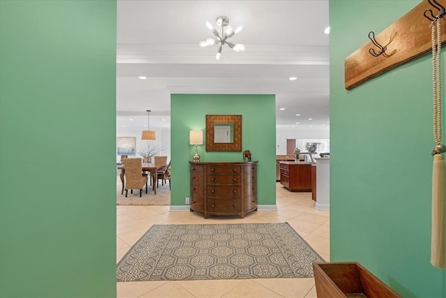 hall featuring an inviting chandelier, light tile patterned flooring, and crown molding