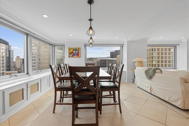 tiled dining space featuring ornamental molding and a healthy amount of sunlight