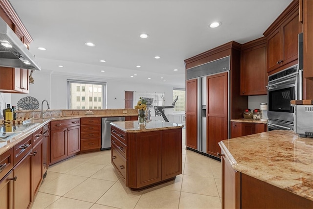 kitchen with island exhaust hood, stainless steel appliances, light stone countertops, a center island, and light tile patterned flooring