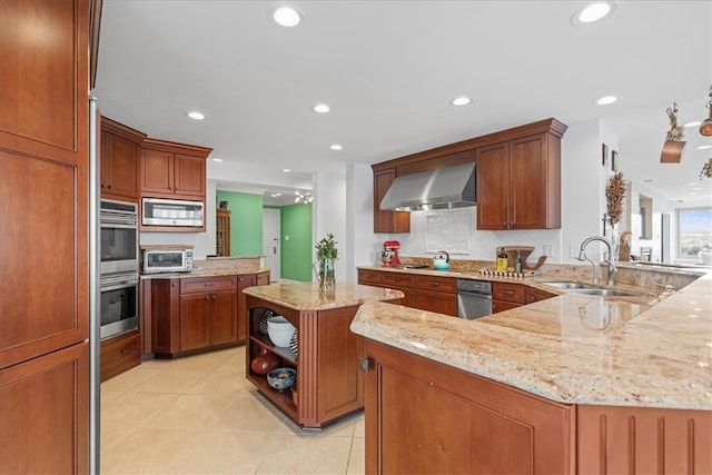 kitchen featuring wall chimney exhaust hood, kitchen peninsula, stainless steel appliances, sink, and light stone countertops