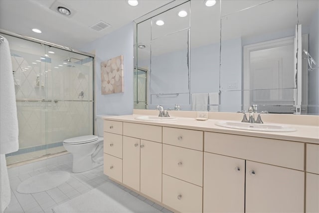 bathroom featuring a shower with door, vanity, toilet, and tile patterned floors