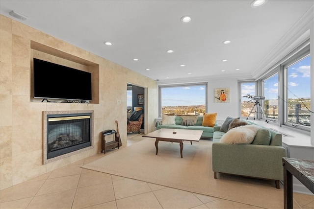 living room featuring plenty of natural light, ornamental molding, light tile patterned flooring, and a fireplace