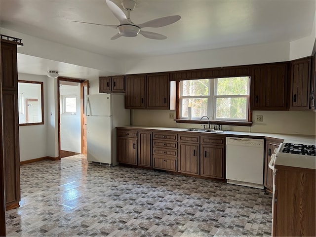 kitchen featuring sink, dark brown cabinets, white appliances, and ceiling fan