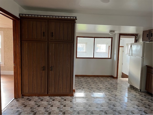 kitchen with dark brown cabinetry and white refrigerator