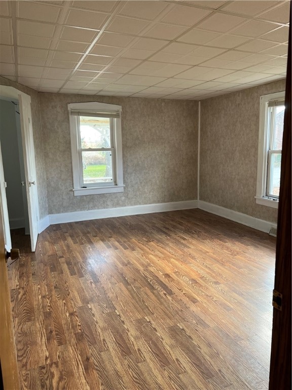 unfurnished room with hardwood / wood-style floors and a paneled ceiling