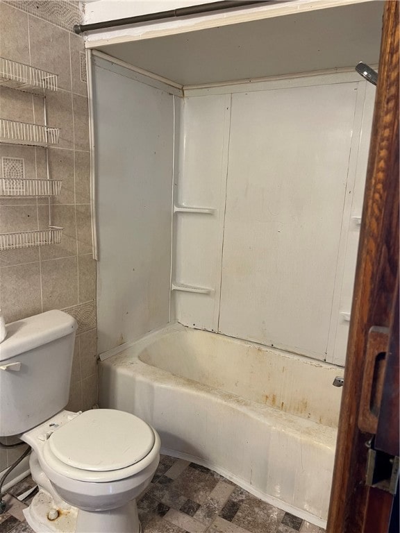 bathroom featuring toilet, bathtub / shower combination, and tile walls