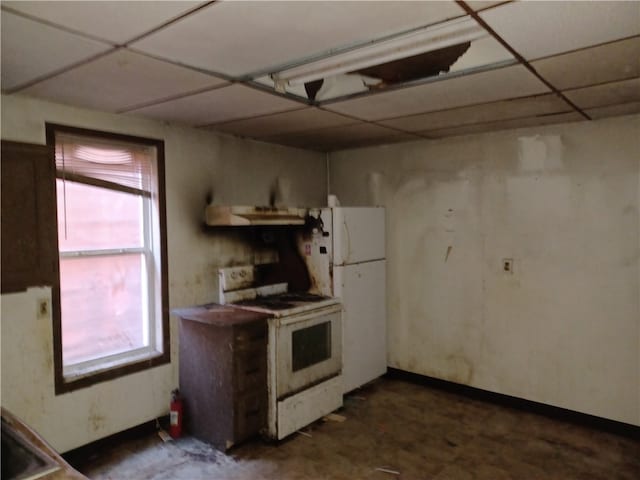 kitchen with a wealth of natural light, range hood, a paneled ceiling, and white appliances