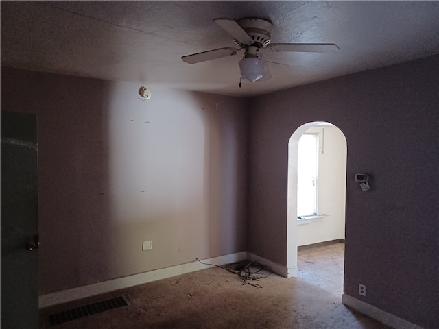 empty room with a textured ceiling and ceiling fan