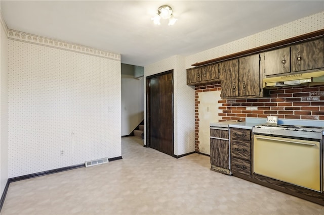 kitchen featuring dark brown cabinets and white range