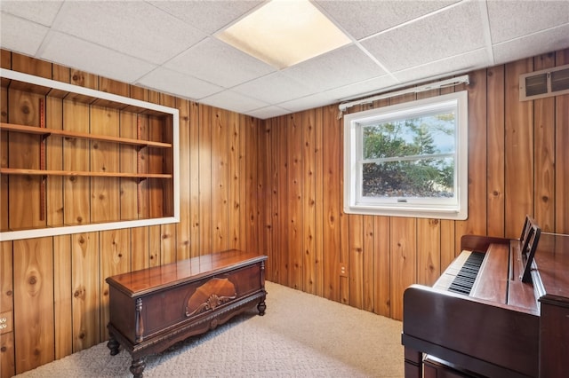 home office with a paneled ceiling and wooden walls