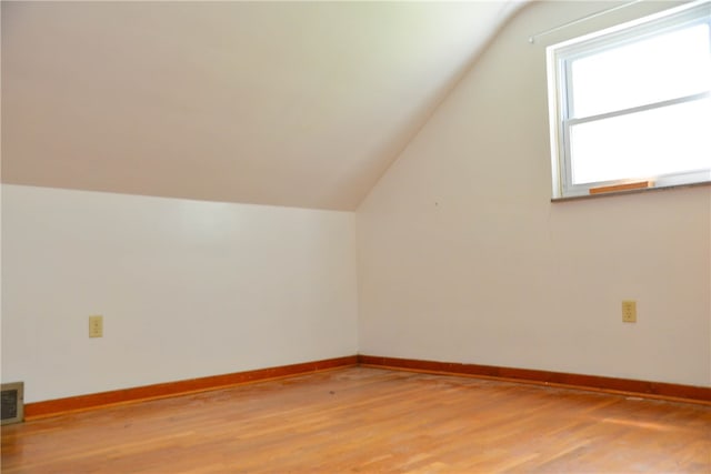 bonus room with light wood-type flooring and lofted ceiling