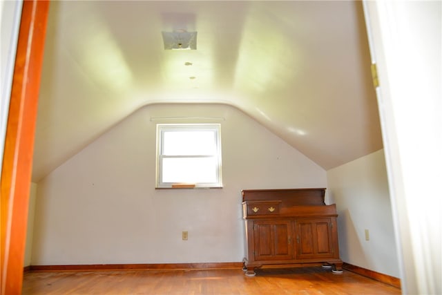 bonus room with light hardwood / wood-style floors and vaulted ceiling