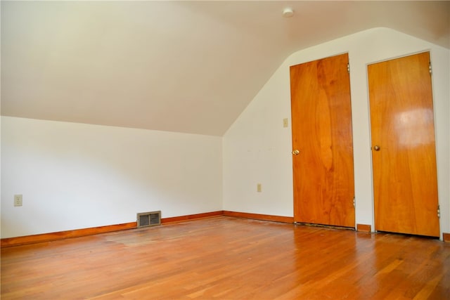 bonus room featuring vaulted ceiling and hardwood / wood-style flooring