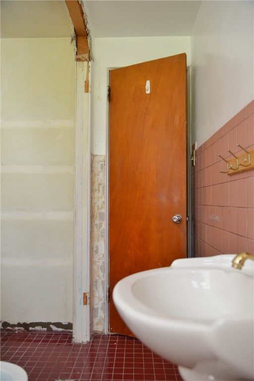 bathroom with tile walls and tile patterned flooring