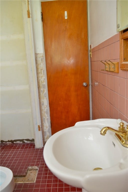 bathroom with walk in shower, tile walls, sink, and tile patterned floors