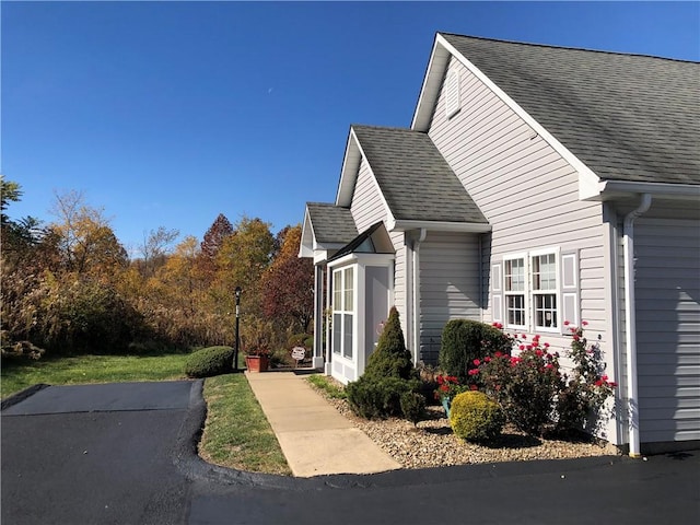 view of side of home with a shingled roof