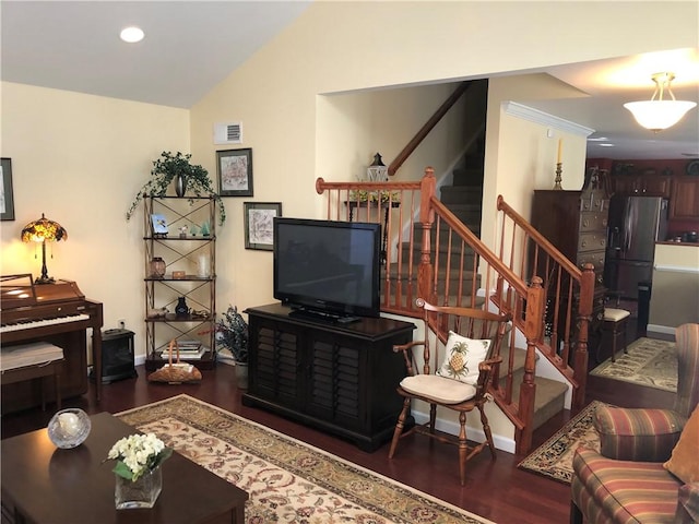 living area featuring visible vents, stairs, wood finished floors, baseboards, and vaulted ceiling