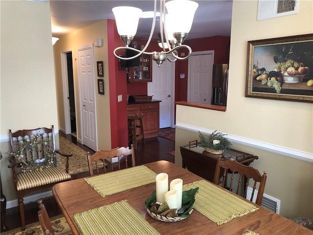 dining area featuring an inviting chandelier and visible vents