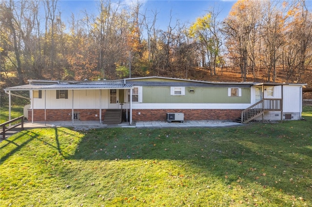 rear view of property featuring a patio area and a lawn