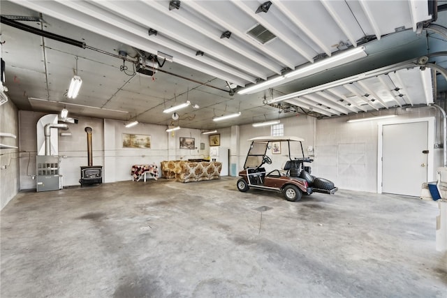 garage with a garage door opener and a wood stove