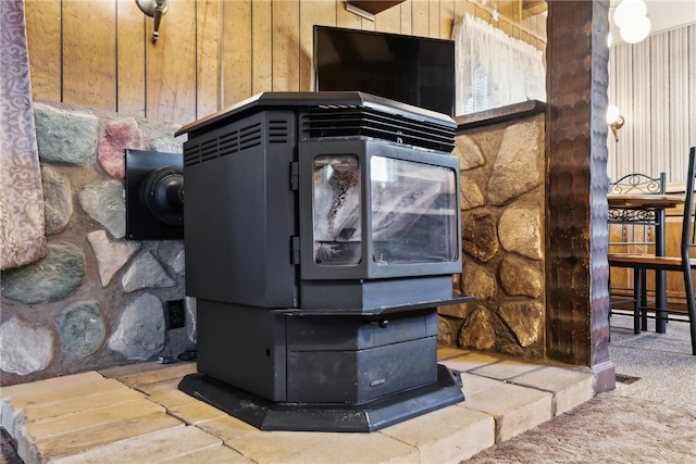 details featuring a wood stove, wood walls, and carpet